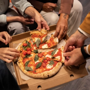 close up hands holding pizza slices