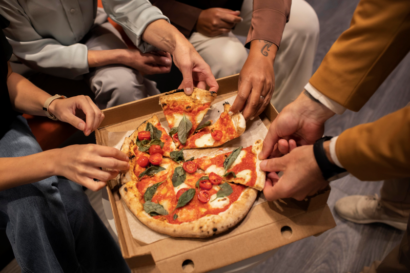 close up hands holding pizza slices